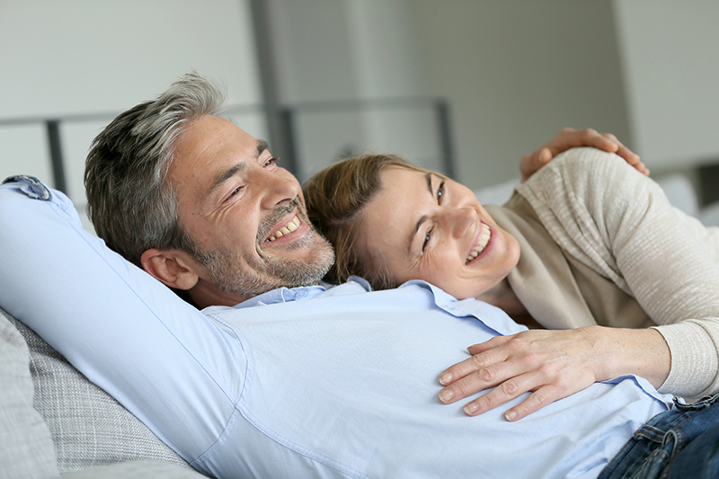 man and woman cuddling on couch